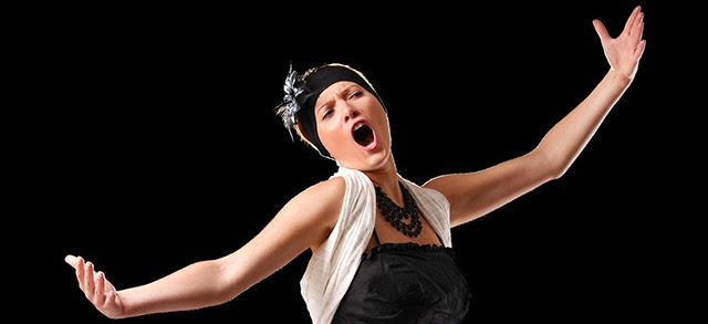 A picture of a young beautiful opera singer performing over black background